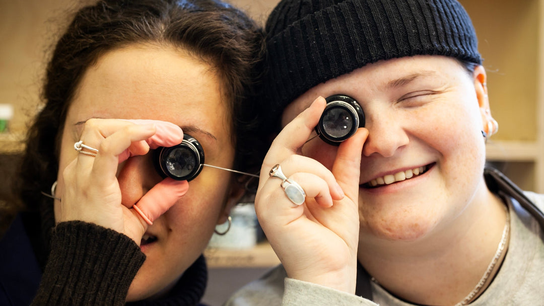 Watch technicians holding magnifying glass to their eyes